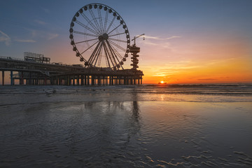Landscape of a sunset at the beach and the pier of Scheveningen with nobody, no tourists, The Hague, Netherlands