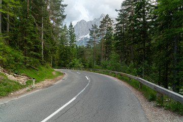 Fototapeta na wymiar Beautiful road for cars in the woods with mountains in the back