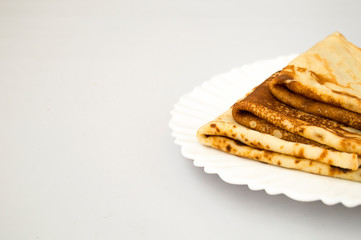 Appetizing Russian pancakes on a white plate. Horizontal food photo