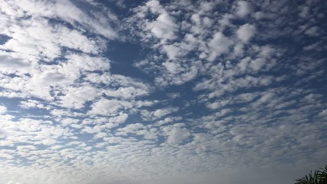 Time lapse clouds, rolling puffy clouds are moving, white lightness clouds time lapse. Ultra HD sunny clouds, Clouds running across the blue sky. Time lapse of white clouds with blue sky in background
