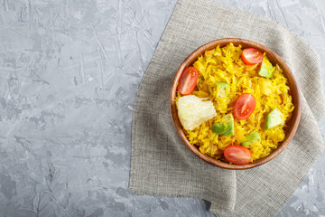 Fried pomelo with tomatoes and avocado in wooden plate on gray concrete background. Top view, copy space.