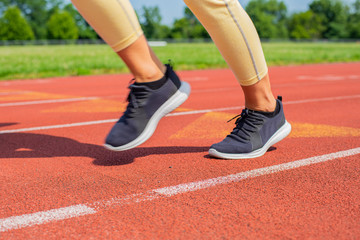 Fototapeta na wymiar Close-up feet of woman on track, runner on running lane