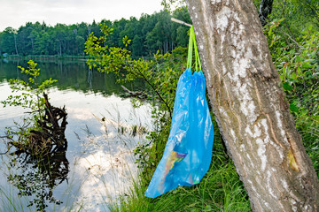 Package with garbage,waste hanging on a tree