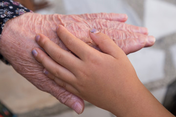 child hands on the old woman wrinkled ,celebrate the victim feast of the elders on the religious feast.happy mother and teachers day.kiss the mum hand.