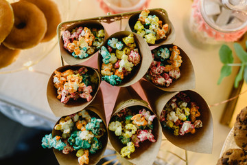 Pop corn in a candy bar beautifully decorated with sweets in a vintage event.