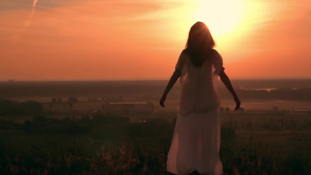 unrecognizable girl with long hair looking on the summer countryside landscape happy female at sunrise