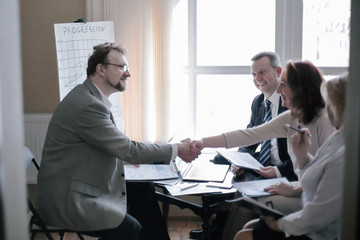 handshake business women and business men near the desktop