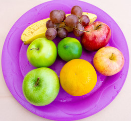 Fruits on a purple tray viewed from above