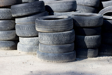 old car tires stacked near the forest. concept of ecological disaster and illegal dumps