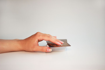 The fortune teller's hand turns over the first card in the Tarot deck on a gray background