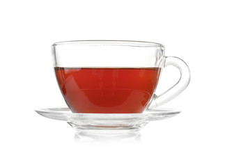 Glass cup of tea and saucer on white background