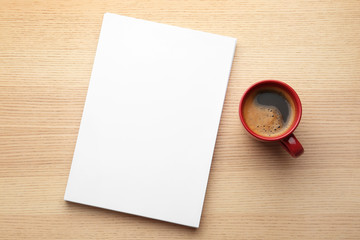 Blank paper sheets for brochure and cup of coffee on wooden background, flat lay. Mock up