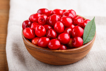 Fresh red sweet cherry in wooden bowl on wooden background. side view.