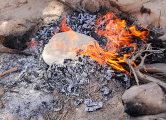 Cooking food, onions, tomatoes and bread, over and open fire. 