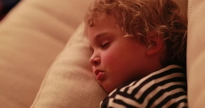 Baby Boy Asleep In Living-room Sofa In Front Of TV Screen