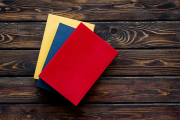 Books for reading on wooden background top view copy space
