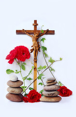 Ein christliches Kreuz mit roten Rosen, Efeu und Steintürmen