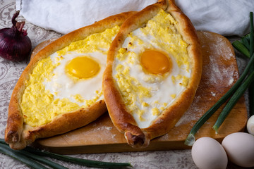 Two Adjar Khachapuri on a wooden board. Oven cake served for food. Georgian cuisine.