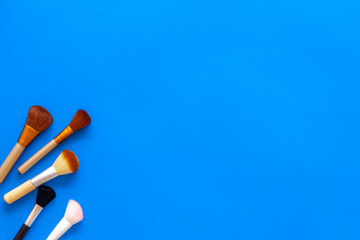 Instruments for make up with brushes on blue background top view mock up