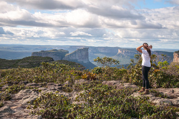 Mulher admirando paisagem do alto da montanha