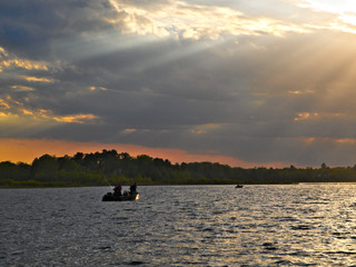 Silhouette of fishermen in a fishing boat on a lake at sunset in Bemidji, Minnesota.