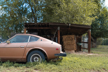 Antique brown car in front of the lean-two in the rural area