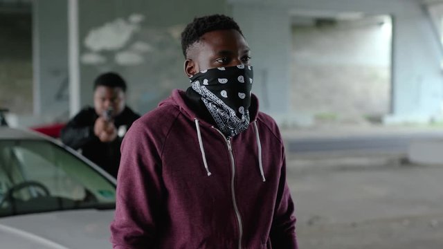 Close up african american offender in mask stand hands up in patrol car in handcuffs burglar crime hold danger gangster gun robber handgun illegal law outlaw arrest bad guy close up slow motion