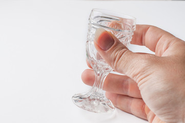 A glass holding a hand isolated on a white background.Hand and glass