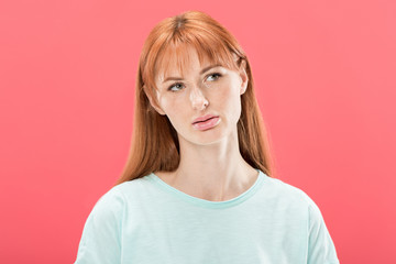 front view of pensive redhead young woman looking away isolated on pink
