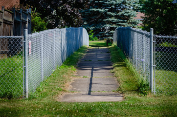Symmetrical entrance of fenced sidewalk pathway