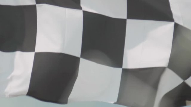 Checkered Flag waving on a blue sky summer day Slow Motion