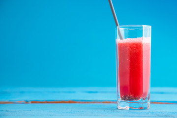 smoothies,freshly squeezed watermelon juice in a transparent glass on a blue wooden background