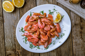boiled shrimp on plate on wooden background