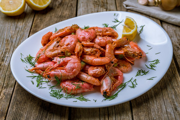 boiled shrimp on plate on wooden background