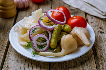 plate of pickles on old wood background
