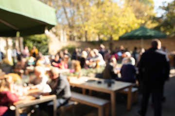 Unfocused group of family and friends having lunch time together on sunny day