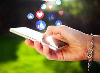 woman's hands using smartphone outdoors - online communication - social media icons