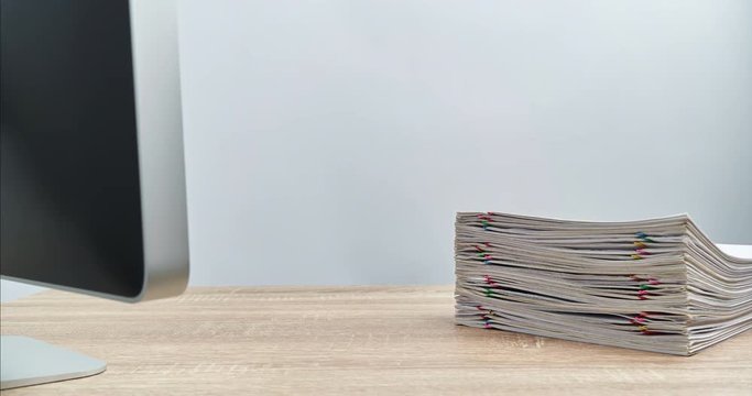 Pile overload paperwork with computer on wood table time lapse