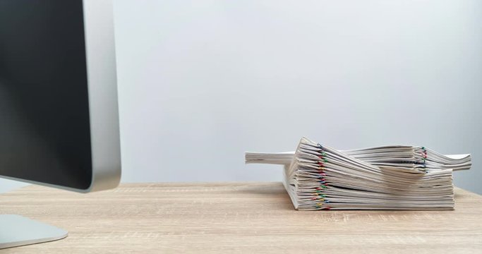 Pile paperwork overload with computer on wood table time lapse