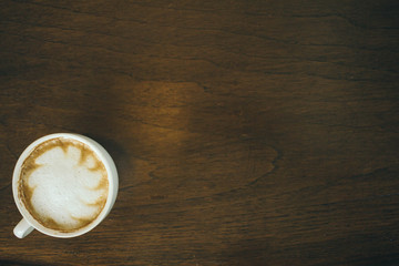 Coffee cup and coffee beans on wooden table  in cafe