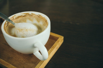 Coffee cup and coffee beans on wooden table  in cafe
