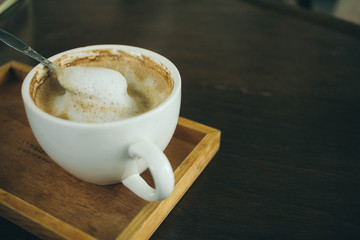 Coffee cup and coffee beans on wooden table  in cafe