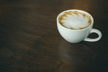 Coffee cup and coffee beans on wooden table  in cafe