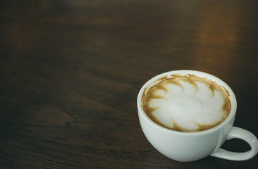 Coffee cup and coffee beans on wooden table  in cafe