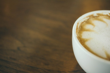 Coffee cup and coffee beans on wooden table  in cafe