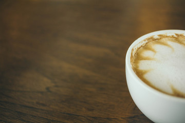 Coffee cup and coffee beans on wooden table  in cafe