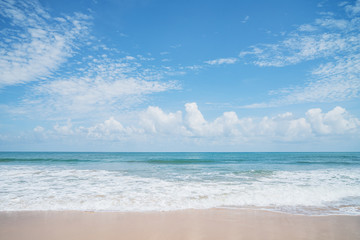 Fototapeta na wymiar Soft wave of blue ocean on sandy beach in summer season. Background with blue sky. 