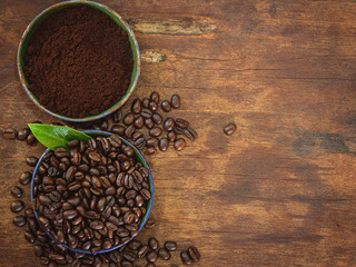 Top view coffee table with copy space for your text, Coffee beans and ground powder on wooden background.