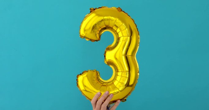 Gold foil number 3 three celebration balloon on blue background