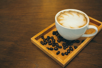 Coffee cup and coffee beans on wooden table  in cafe